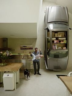 a man standing next to a kitchen with a dog on the floor