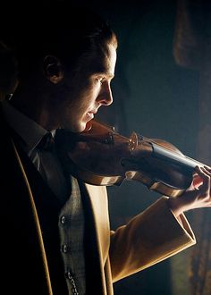 a man in a suit drinking from a wine bottle while holding a violin string to his mouth