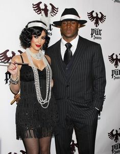 a man and woman dressed up for a costume party, posing for the camera on the red carpet