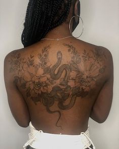 the back of a woman's body with tattoos on it