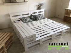 a bed made out of pallet wood in a room with white walls and flooring