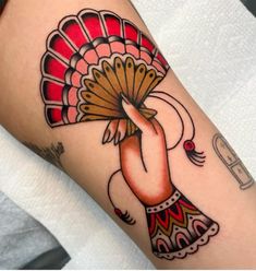 a woman's arm with a tattoo design on it and a fan in the middle