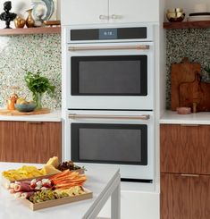 two ovens in a kitchen with wooden cabinets and white counter tops, one is built into the wall