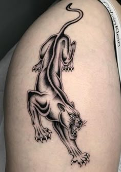 a black and white tattoo of a lion on the back of a woman's thigh