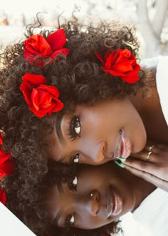 two women with red flowers in their hair