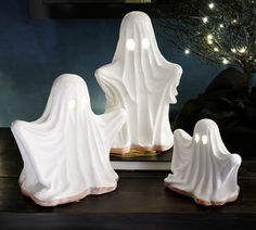 three white ghost figurines sitting on top of a table