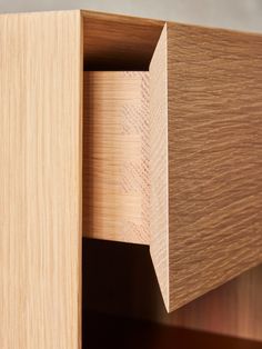 a close up view of the corner section of a wooden cabinet with wood grains