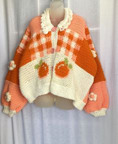 an orange and white knitted sweater with pumpkins on it