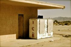 an old refrigerator sitting in front of a building