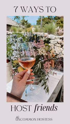 a person holding a wine glass with the words 7 ways to host friends uncommon hostess