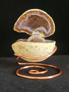 a wedding ring sits in an agate stone bowl