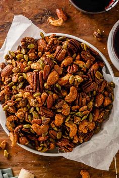 a white bowl filled with nuts on top of a wooden table