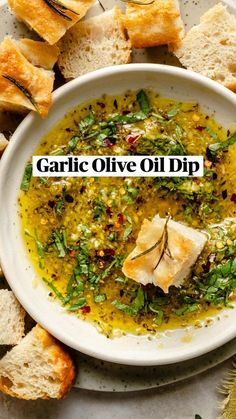 garlic olive oil dip in a white bowl with bread on the side and green garnish