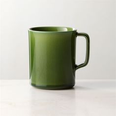 a green mug sitting on top of a white counter