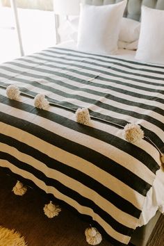 black and white striped bedspread with pom - poms on it