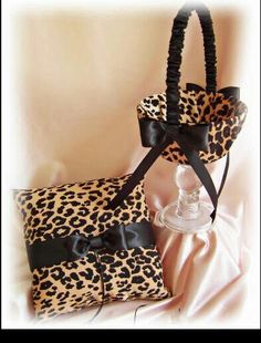 a cheetah print bag and wine glass holder on a pink satin sheet with black ribbon