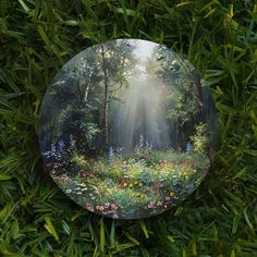 a glass plate sitting on top of a lush green field filled with wildflowers