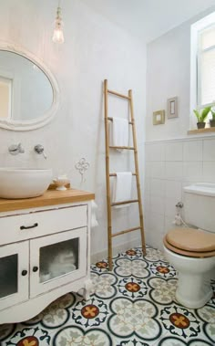 a bathroom with a ladder leaning up against the wall next to a toilet and sink