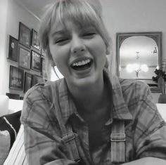 a woman laughing while sitting on a couch