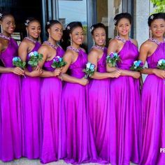 a group of women in purple dresses standing next to each other