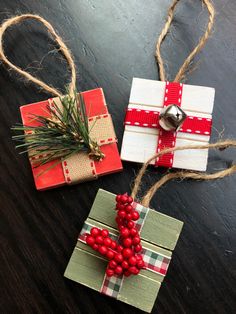 two wrapped presents on a table with twine and pine needles tied to them, one is decorated like a cross