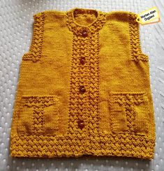 a yellow knitted vest sitting on top of a white bed next to a tag