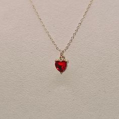 Gold 18 inch necklace with a red heart shaped pendant. Red Heart Cut Necklace For Party, Red Heart Pendant Necklace For Party, Dainty Red Heart Necklace With Charm, Dainty Red Heart Necklace With Heart Charm, Cute Red Heart Pendant Necklace, Red Clavicle Chain Necklace For Valentine's Day, Dainty Red Heart Charm Necklace, Gold Red Heart Necklace, Red Heart Necklace With Delicate Chain