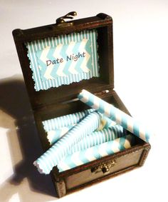 an open wooden box with paper straws inside on a white tableclothed surface