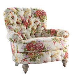 an upholstered chair with flowers on the back and arms, sitting in front of a white background