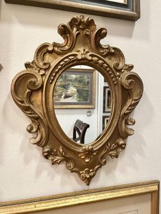 a gold framed mirror sitting on top of a wall