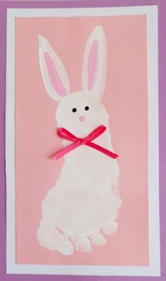 an easter bunny card with pink background and red ribbon tied around it's neck