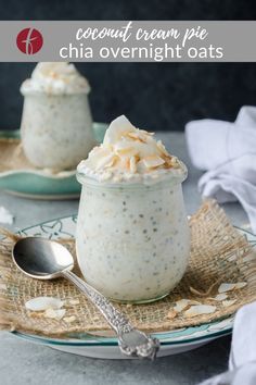 two small jars filled with food on top of a plate next to a spoon and napkin