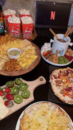 a table topped with pizza and other foods