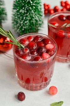 two glasses filled with cranberry punch surrounded by christmas decorations