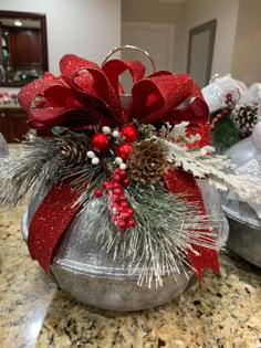 a christmas centerpiece with pine cones and berries