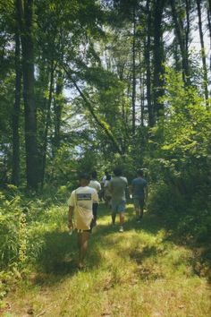 several people walking down a path in the woods