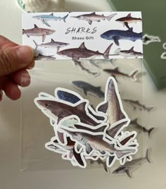 a person holding up a sticker with sharks on it