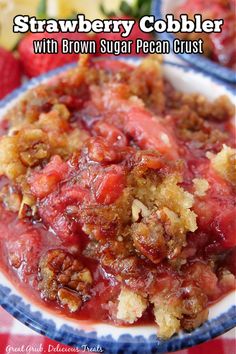 strawberry cobbler with brown sugar pecan crust on a blue and white plate next to strawberries