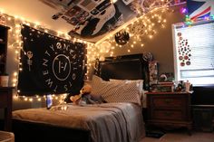 a bed room with a neatly made bed and lots of lights on the wall above it