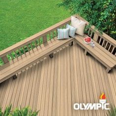 an aerial view of a wooden deck with pillows on it and trees in the background