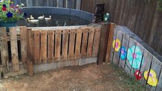 an outdoor hot tub with flowers painted on the side and ducks in the water next to it