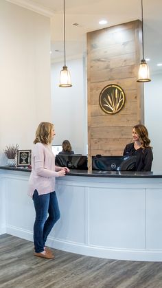 two women standing at the front desk of a hotel