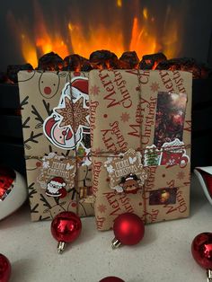 three christmas gift bags sitting in front of a fire