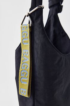 a black bag with a yellow and blue ribbon hanging from it's front pocket