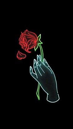 a person's hand holding a rose lit up in the dark with neon lights