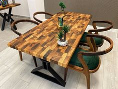 a wooden table with two chairs and a potted plant on top of the table