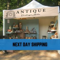 the tent is set up with antiques for sale on it's sides and next day shipping