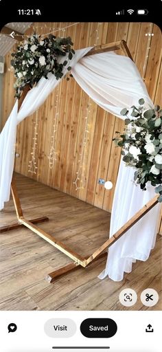 the wedding arch is decorated with white flowers and greenery