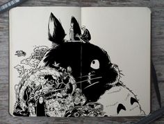 a black and white drawing of a rabbit in the middle of an open book on a wooden table