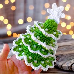 a hand holding a small green crocheted christmas tree